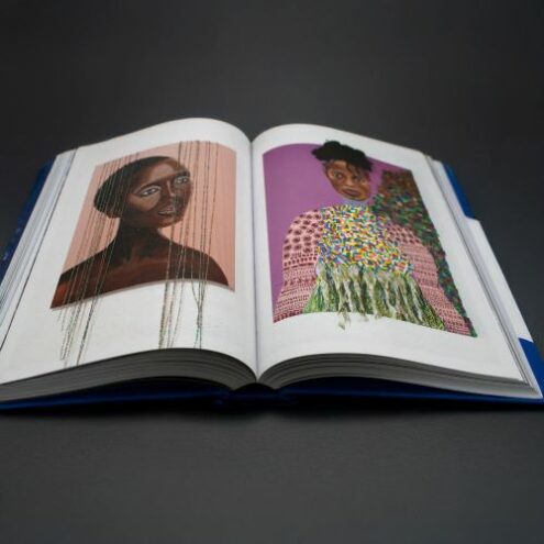 Photo of open coffee table book showing artwork by Latoya Lovely