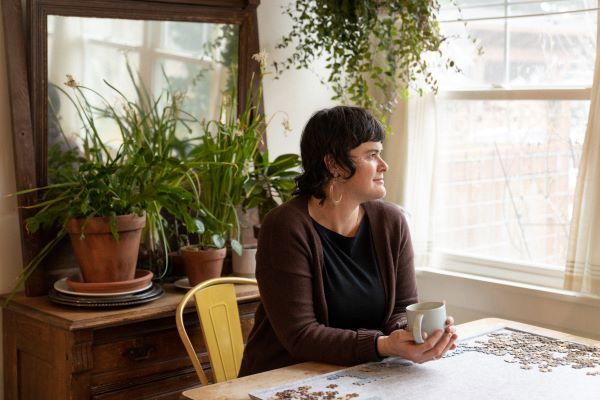Photo of Corinna Luyken sitting at table holding mug