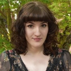 person with dark hair in a flowered dress
