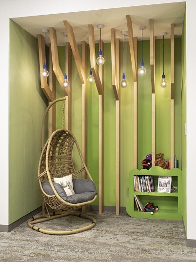 Green nook with hanging chair and small bookshelf