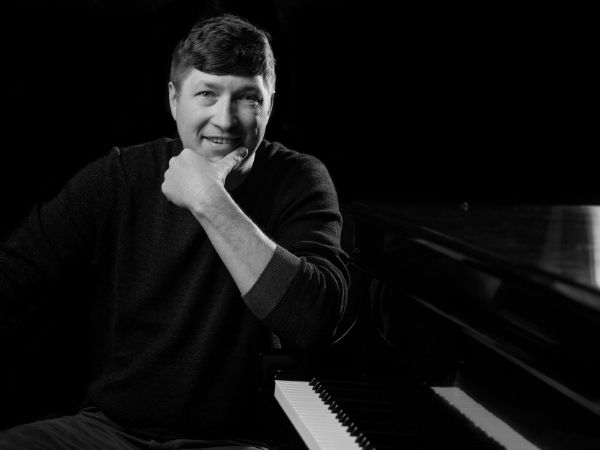Black and White Photo of Mike Alston sitting at a piano