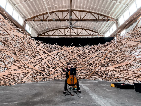woman playing cello inside a large sculpture